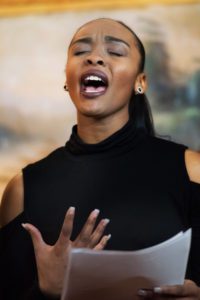 African American woman speaking at a performing arts event during #metoo